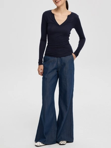Detail view of the V-neck knit shirt showing slim fit texture and deep blue denim fabric