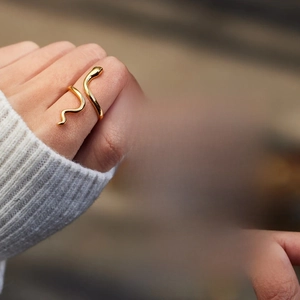 Detailed view of a gold snake ring with an inspirational greeting card for daughter