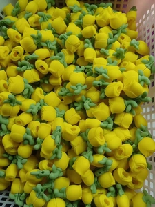 Macro shot of bulk yellow tulip silicone cable protectors in a plastic bin