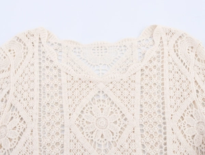 Detailed close-up of ivory crochet lace blouse featuring floral hollow knit patterns