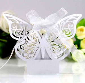 Macro detail of white laser-cut butterfly favor box with ribbon for baptism and parties