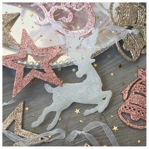Close-up of glittery white reindeer and golden JOY letter ornaments for Christmas decor