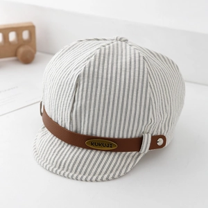 Detail of striped cotton baby baker boy hat with PU leather strap and KUKUJI metal tag