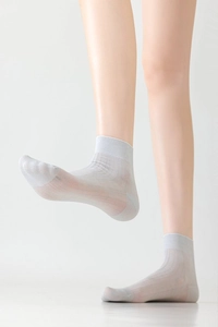 Close-up of thin light gray silk mesh socks showing breathable texture and snug fit