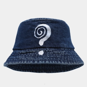 Detailed view of white artistic embroidery on a dark blue denim bucket hat
