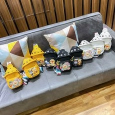 Three colors of mini cartoon canvas shoulder bags displayed on a modern sofa