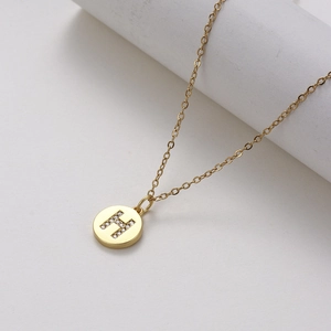 Close-up of a gold circular pendant featuring micro-pave zircon letter H on O-chain