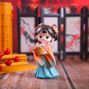 Close-up of a cute Chinese style figurine holding a flower basket in orange gradient dress
