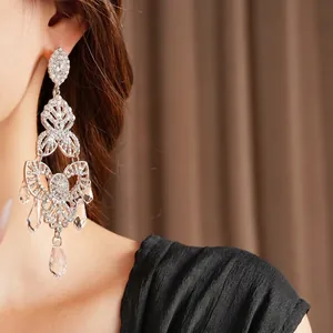 Vintage silver tassel earrings with flower drop crystals shown on a model side view