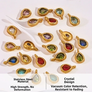 Macro detail of colorful teardrop crystal pendants with gold plated wavy stainless steel frames