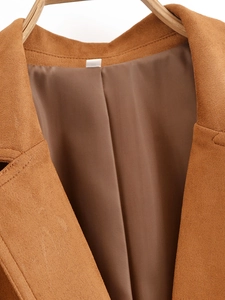 Dettaglio del blazer in pelle scamosciata marrone con trama del bavero e fodera interna