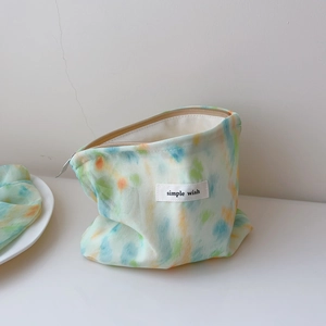 Detail of mint green tie-dye fabric storage bag with a simple wish label and zip closure