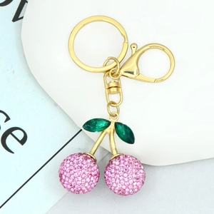 Detailed view of pink rhinestone cherry keychain with green leaves on gold plating
