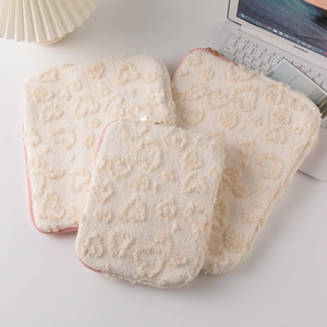 Detailed plush heart texture on off-white laptop sleeve with pink zipper and soft finish