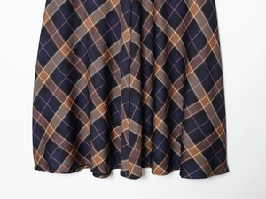 Detail view of the classic blue and caramel plaid pattern and woven fabric of the skirt