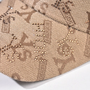 Close-up of fabric texture and rhinestone embroidery on this brown plaid baseball cap