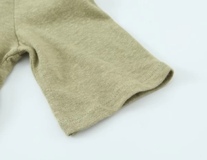 Macro view of grey-green linen blend T-shirt sleeve with detailed stitching and texture