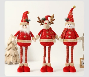 Close-up of plush Christmas dolls showing knitted fabric texture and festive red details