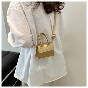 Detailansicht der kleinen goldenen Handtasche mit abnehmbarem Schultergurt als Umhängetasche