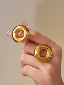 Close-up of polished gold hollow ring with smooth minimalist donut-shaped design