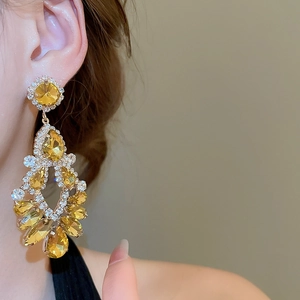 Macro shot of elegant amber teardrop crystal earrings with shimmering white rhinestones