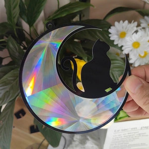 Detailed view of crescent moon and cat suncatcher reflecting vibrant rainbow light prisms