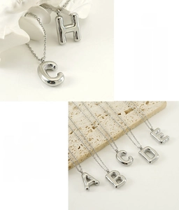 Detail of 3D puffy balloon initial pendants in stainless steel with hypoallergenic finish