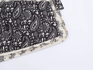 Dettaglio macro del motivo paisley trapuntato sul tessuto di un gilet imbottito