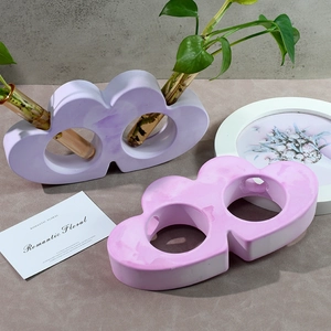 Close-up of cloud-shaped hydroponic vase with twin glass tubes in soft purple and pink