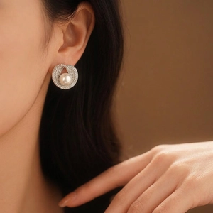 Minimalist silver earrings with zircon circle and round pearl, worn by a female model