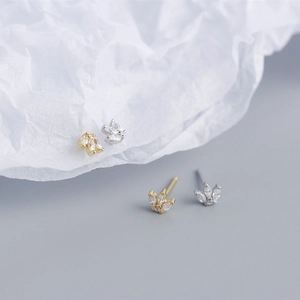 Macro shot of silver and gold crown stud earrings with clear cubic zirconia crystals