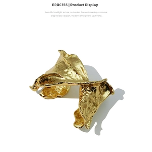 Macro detail of gold irregular lava texture on an open spring bangle for women