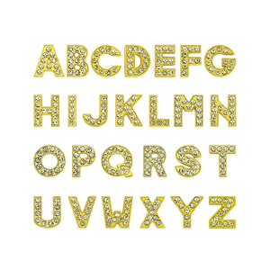 Close-up of 26 alphabet charms with gold metal edges and white rhinestones for DIY bracelets
