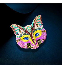 Macro detail of vintage cat mask brooch featuring colorful enamel and inlaid rhinestones