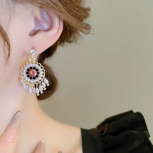 Detail shot of vintage crystal flower drop earrings with pink center stone and purple beads