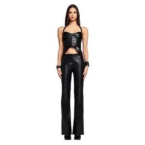 Full body shot of a model in a black faux leather halter crop top and matching trousers