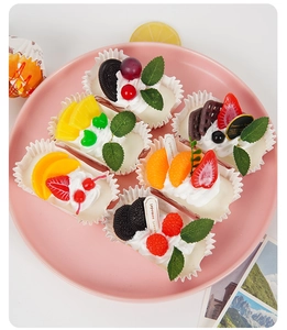 Set of 6 realistic artificial fruit cupcakes with berries on a pink decorative plate