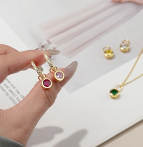 Detail of 925 sterling silver birthstone pendants with colorful zircons and gold plating