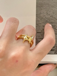 Detailed view of a gold irregular star-shaped S925 silver ring worn on a finger