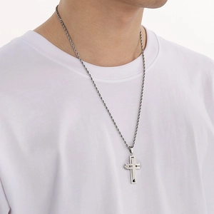 Silver cross pendant with twisted chain on a model, showcasing minimalist hip-hop design
