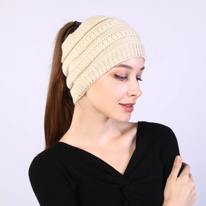 Close-up of beige knit headband showing elastic texture and hollow weave pattern