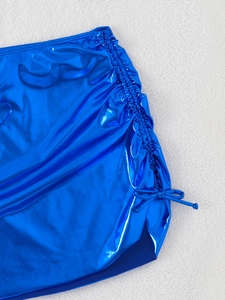 Detail of metallic blue skirt with side drawstring ruching and glossy finish