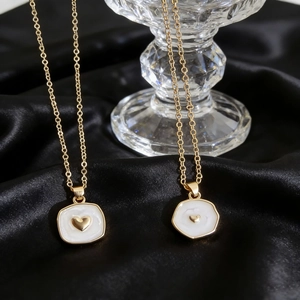 Golden star and moon heart pendant necklace on black silk fabric background