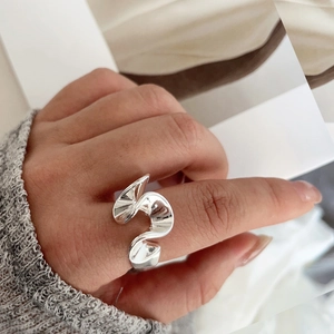 Dettaglio ravvicinato di un anello d'argento ondulato con un design ritorto unico sul dito