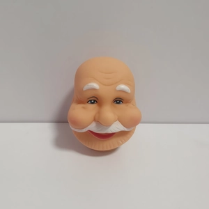 Detailed close-up of a soft vinyl Santa Claus head with white beard for DIY ornaments
