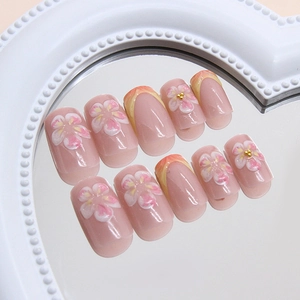 Faux ongles French dégradé rose avec relief floral 3D et perles dorées