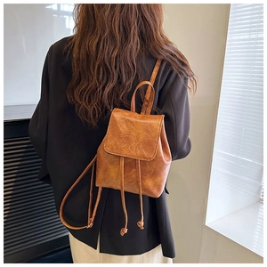 Detail view of mini caramel backpack featuring vintage PU leather texture and drawstring