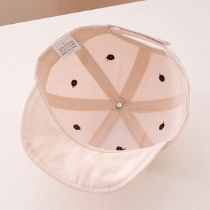 Detail of baby cotton cap interior showing 100% cotton label and reinforced stitching