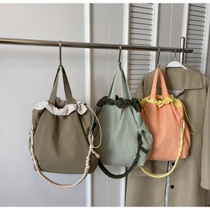 Dettaglio borse a secchiello in nylon con coulisse in oliva, verde salvia e rosa pesca