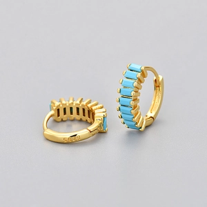 Close-up of gold hoop earrings with turquoise stones and S925 silver hallmark engraving